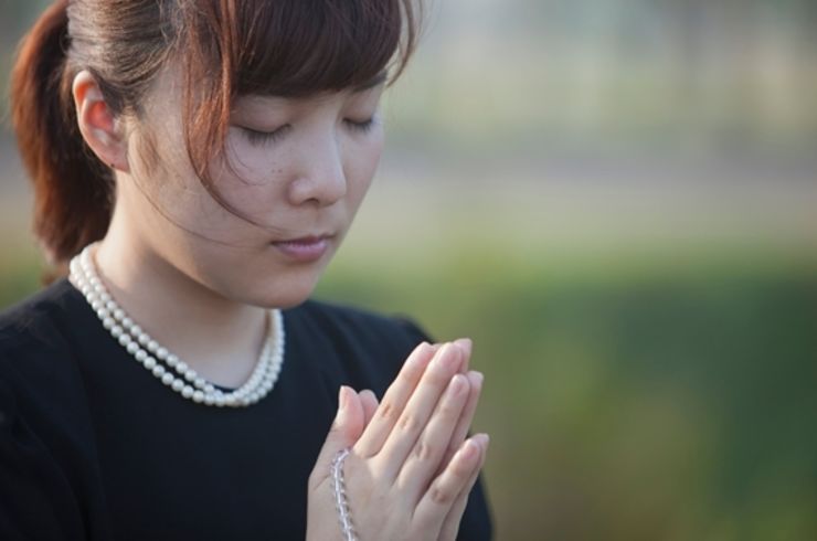 手を合わせる女性